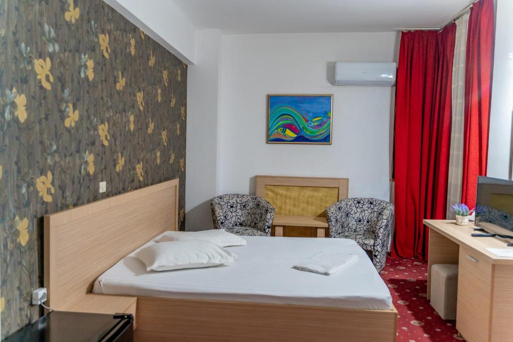 Un pat sau paturi într-o cameră la Hotel Dambovita