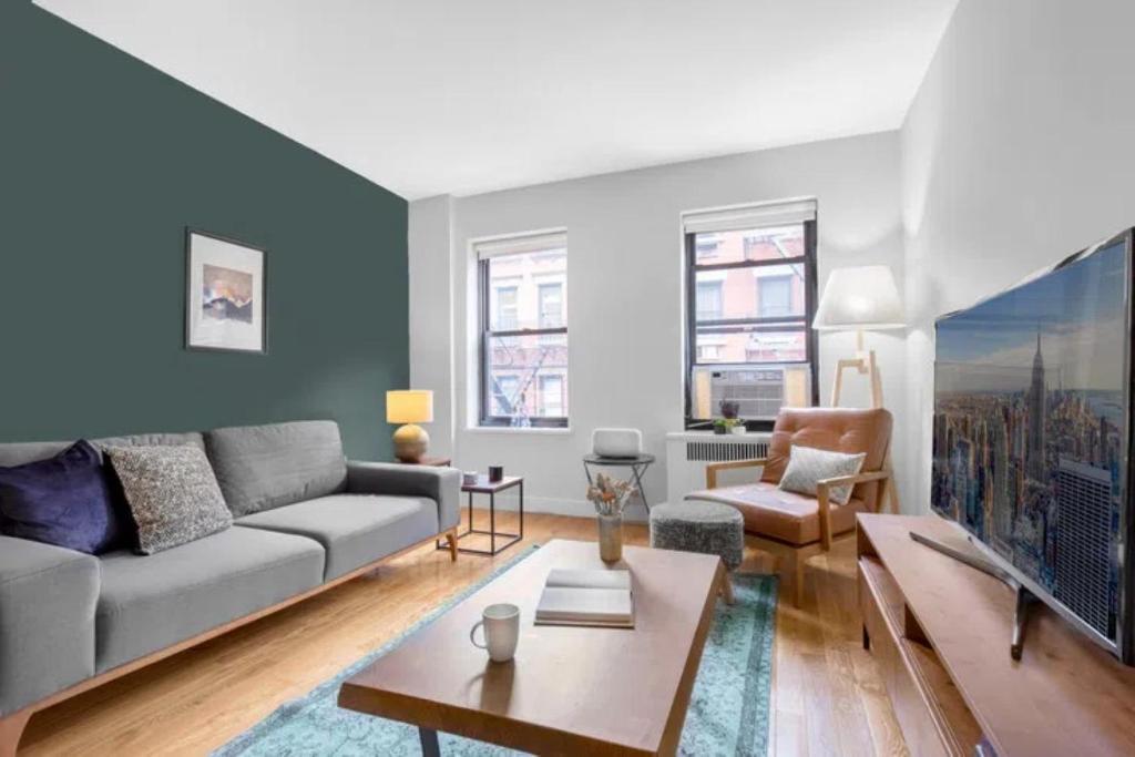 uma sala de estar com um sofá e uma mesa em Warm and Comfortable 3 BR em Nova York