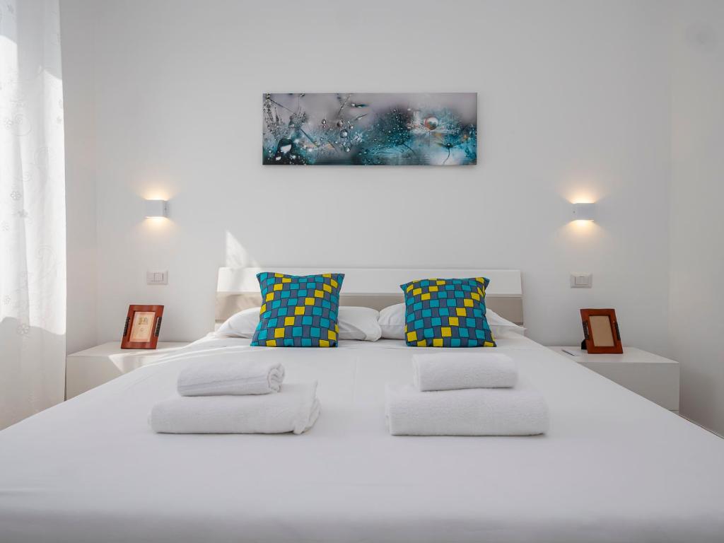 ein weißes Schlafzimmer mit einem großen weißen Bett mit Kissen in der Unterkunft [IHost Apartment] - Rogoredo 27 in Mailand