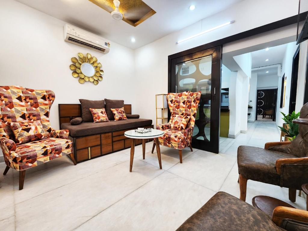 uma sala de estar com um sofá e cadeiras em Furnished 2BHK Independent Apartment 7 in Greater Kailash - 1 Delhi em Nova Deli