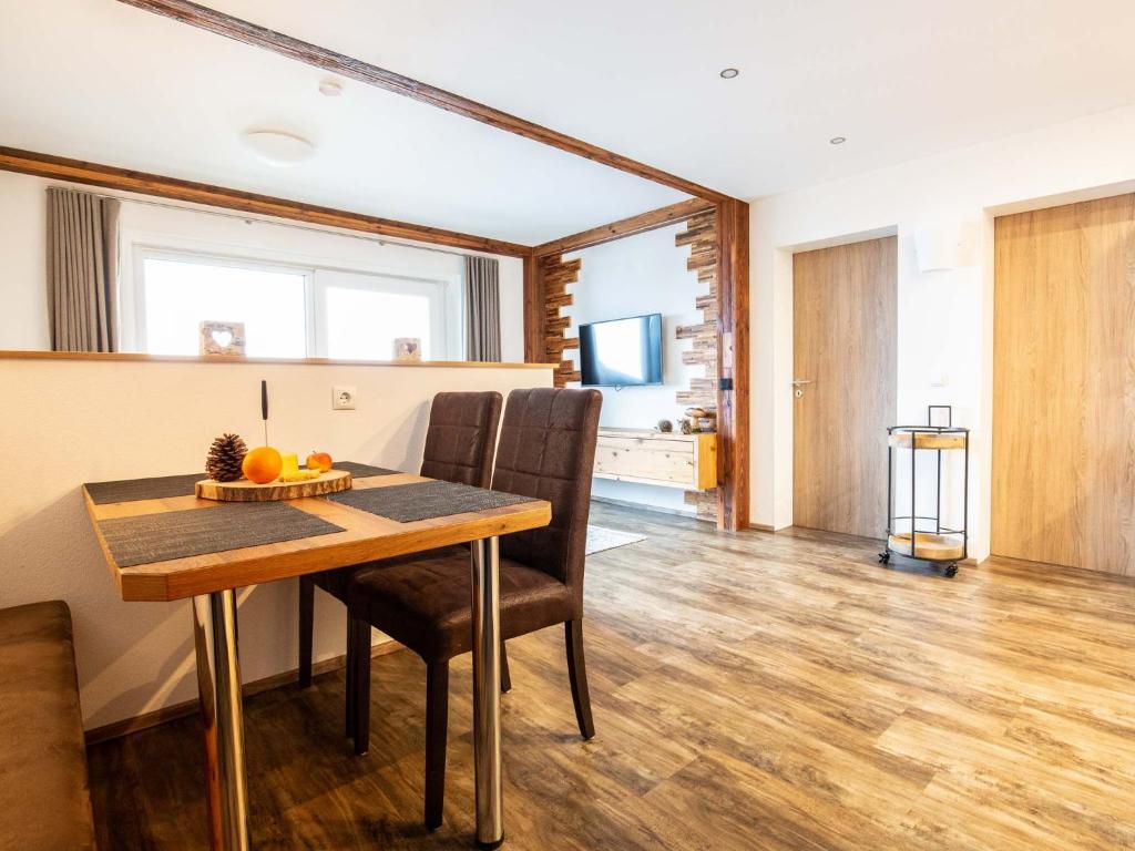 a dining room with a wooden table and chairs at Adlernest in Riezlern