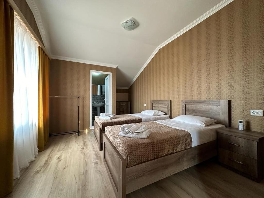 1 dormitorio con 2 camas y ventana en Happy House en Kutaisi