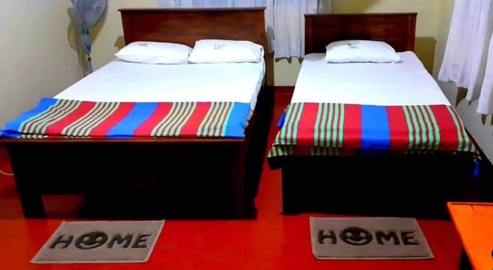 two beds in a room with no one signs on them at Green Agua Lodge in Belihul Oya