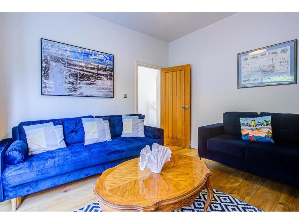濱海紹森德的住宿－Pass the Keys Stunning house in Leigh，客厅配有蓝色的沙发和桌子