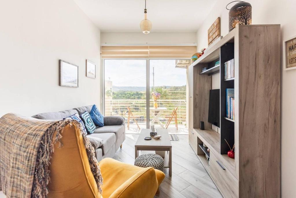 - un salon avec un canapé et une télévision dans l'établissement Gozo Escape 2-Bed Apartment in Marsalforn, à Marsalforn