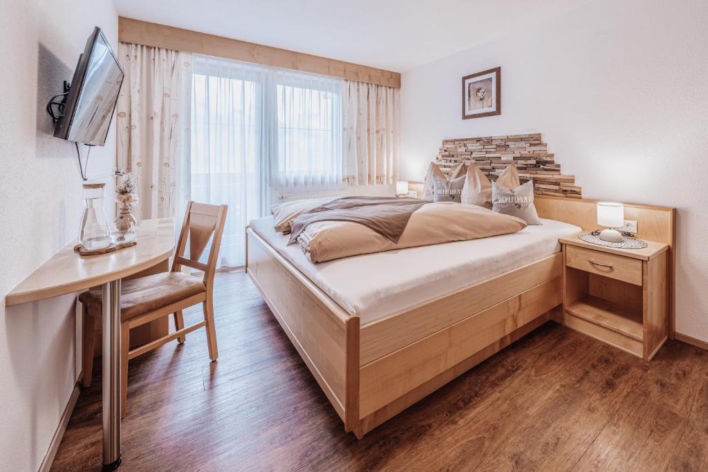 a bedroom with a bed and a desk and a television at Auer-Fiegl in Sölden