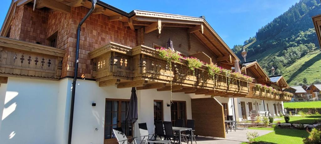 um edifício com uma varanda com mesas e cadeiras em Hochalmbahnen Chalets Rauris 1-20 WE4, Maislaufeldweg 1r OG em Rauris