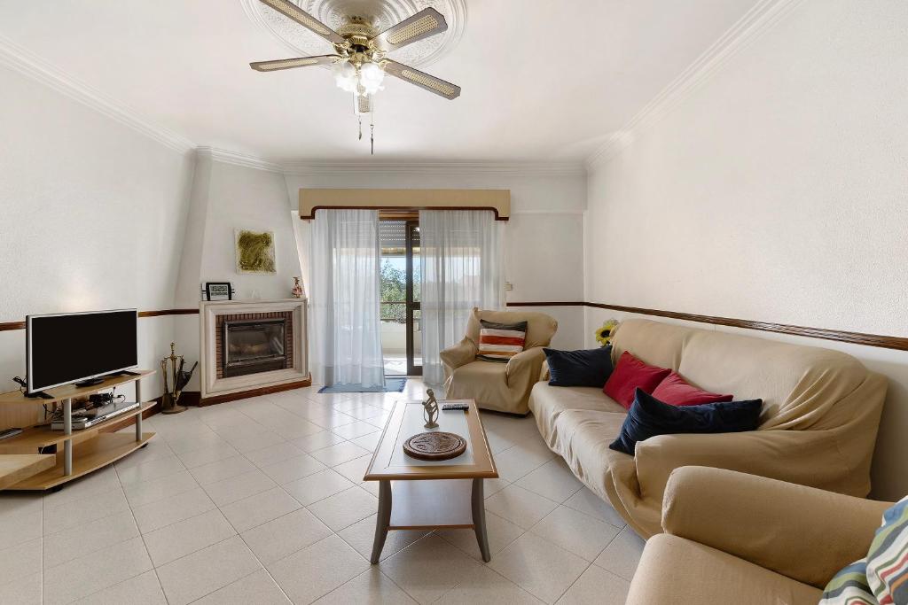 a living room with a couch and a tv at Augusta's House in Cascais