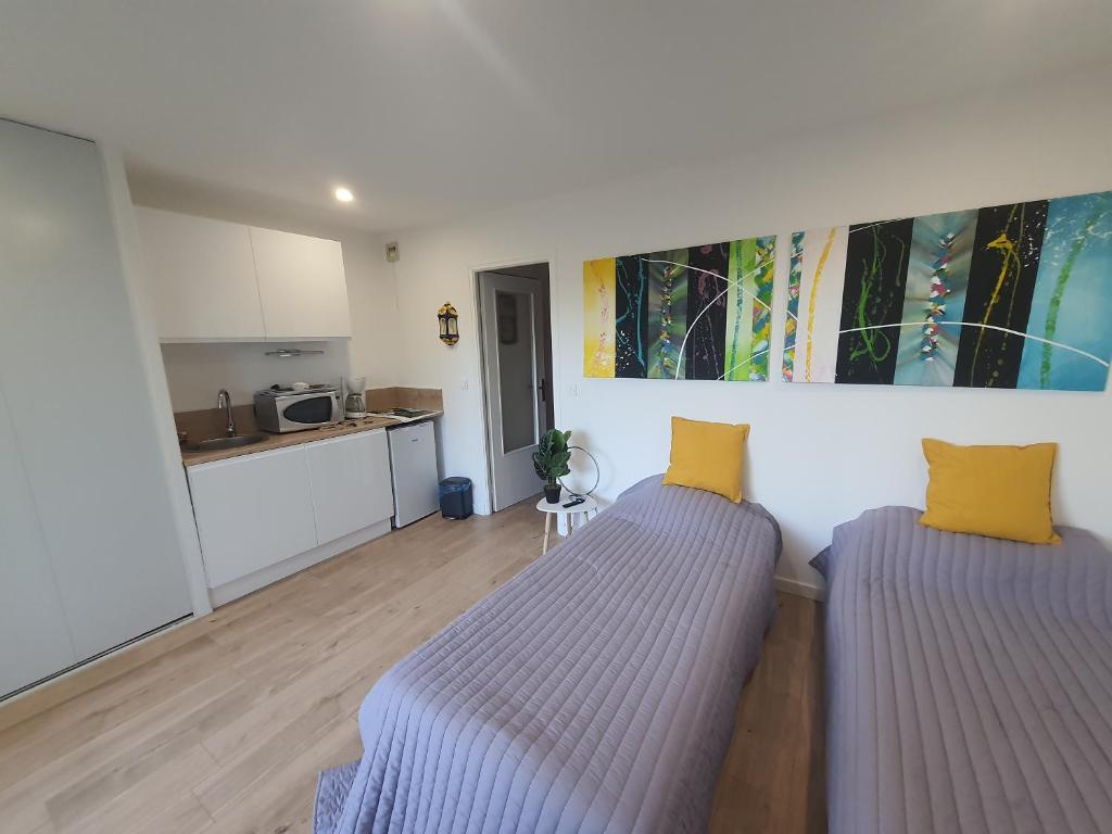 - 2 lits dans une chambre avec cuisine dans l'établissement Studio Amèlie les bains, à Amélie-les-Bains-Palalda