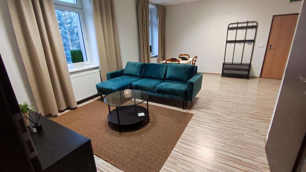 a living room with a blue couch and a table at Apartmán RADKA in Zvolen