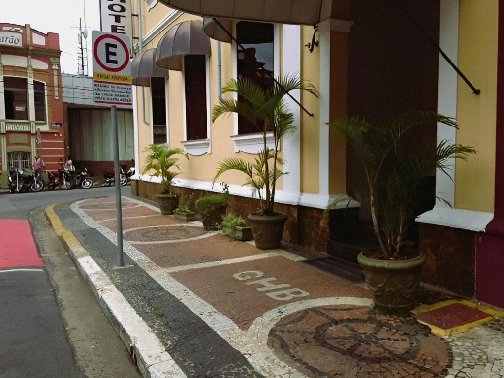 uma rua com vasos de plantas ao lado de um edifício em Grande Hotel Bragança em Bragança Paulista