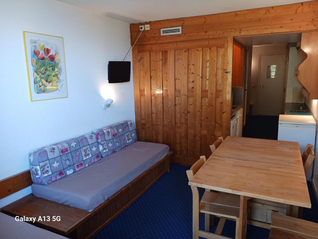 Cette petite chambre comprend un canapé et une table. dans l'établissement Studio Les Arcs 1800, 1 pièce, 4 personnes - FR-1-411-426, à Arc 1800