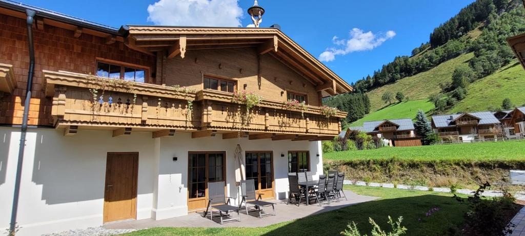 a building with a balcony with tables and chairs at Hochalmbahnen Chalets Rauris 1-18, Maislaufeldweg 1t in Rauris
