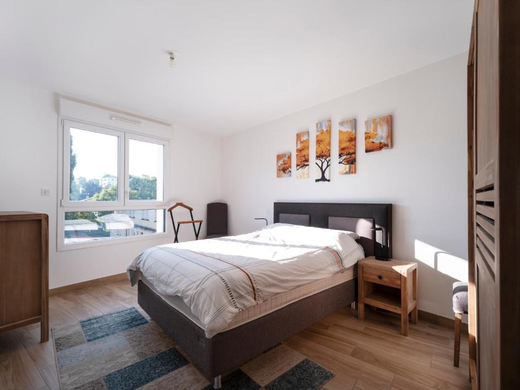 ein Schlafzimmer mit einem Bett und einem Fenster in der Unterkunft AZALEE - Parking gratuit - Terrasse couverte - Proche transport - Tout équipé in Nancy