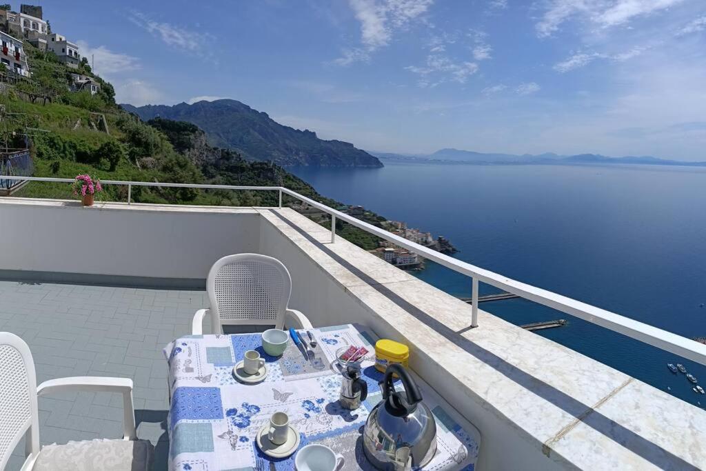 a table and chairs on a balcony overlooking the water at Casa Vacanze La Rosa Del Mare in Amalfi