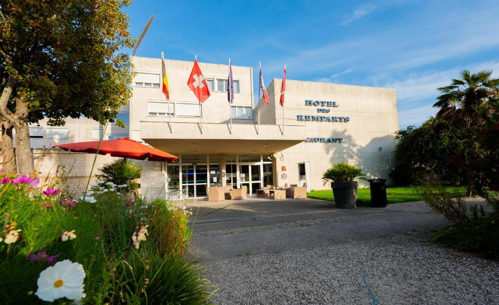 un edificio con banderas en la parte delantera en Hôtel & Restaurant des Remparts, en Rochefort