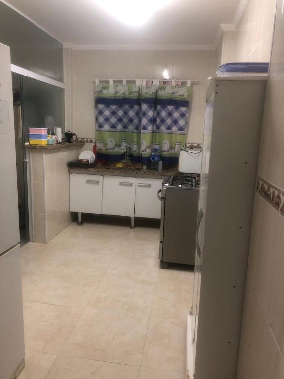 a small kitchen with a stove and a refrigerator at Odil in Praia Grande