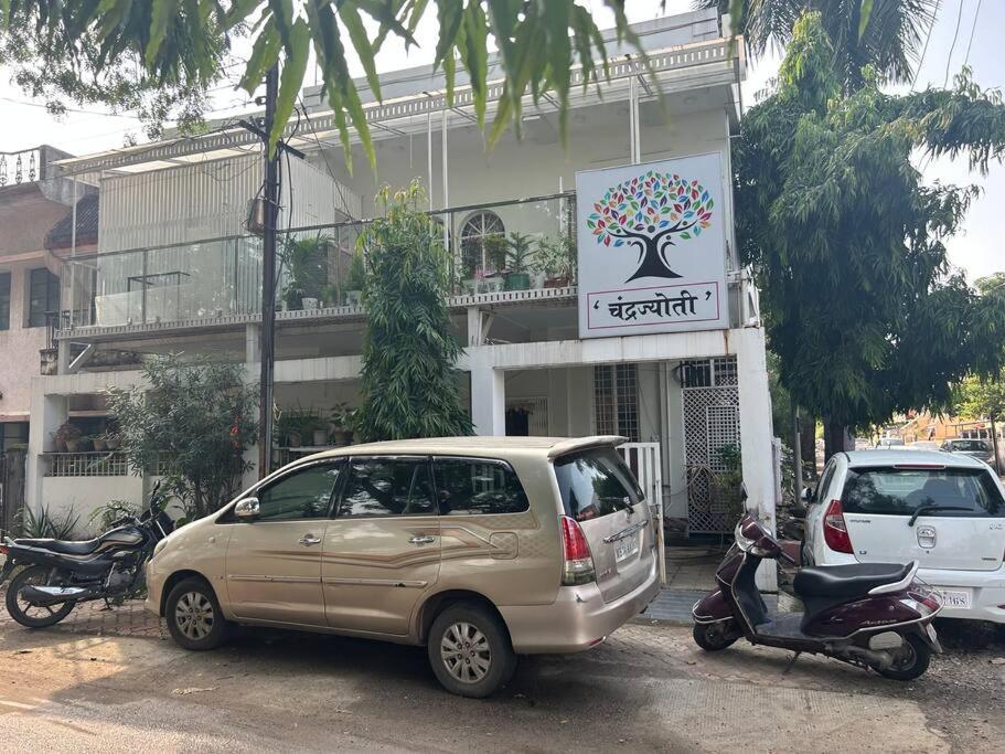 uma carrinha e uma scooter estacionadas em frente a um edifício em 2BHK Chandra Jyoti Villa NIT Garden Nagpur em Nagpur