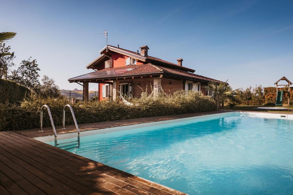 uma casa com piscina em frente a uma casa em Villa Gramolina Nizza em Nizza Monferrato