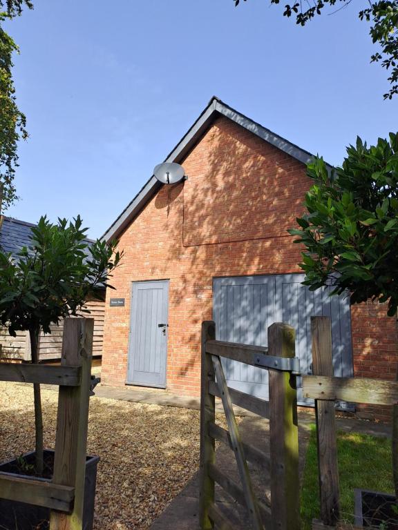 een bakstenen gebouw met een hek en een hek bij Stone Barn in Farnham