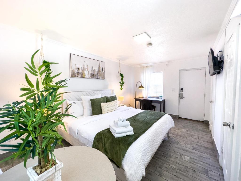 a bedroom with a large white bed and a plant at King Suite Apt With Shared Pool 02 in Clearwater