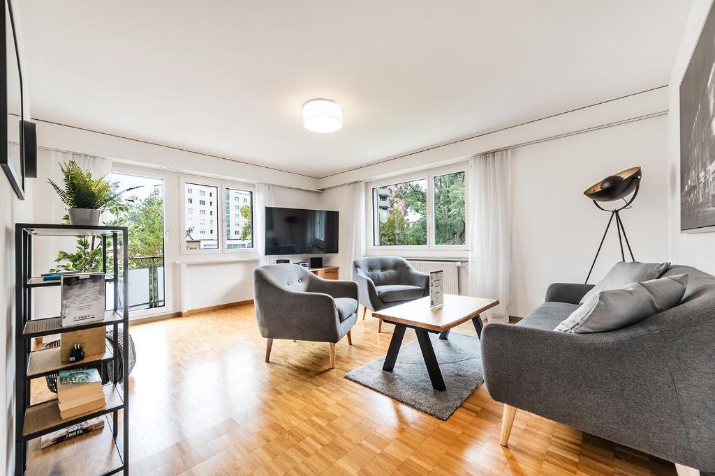uma sala de estar com um sofá, cadeiras e uma mesa em Cooldis 11 !Gratis Parken, Free Parking! em Kreuzlingen