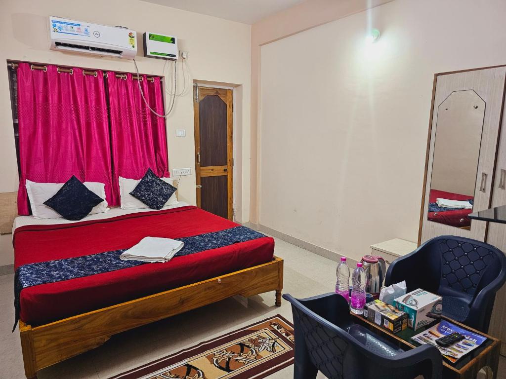 a bedroom with a red bed with a red window at Bay Inn in Puri