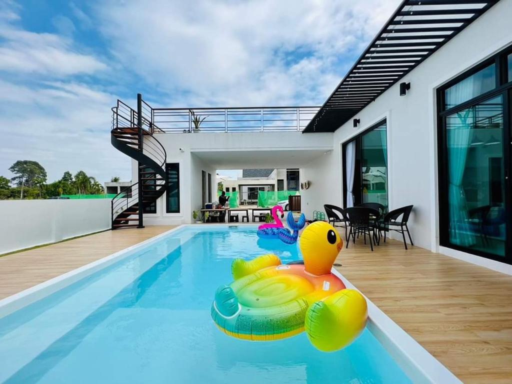 una piscina con un pato de goma en medio de una casa en Pangpangpuriyeh Poolvilla en Ban Pa Khan