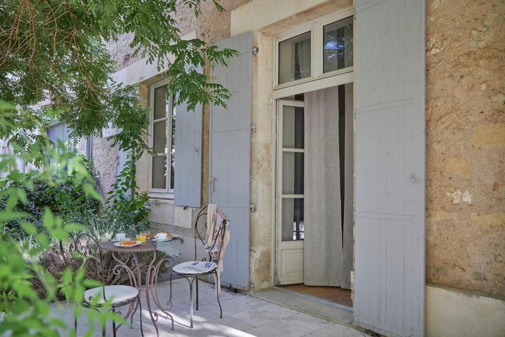 a patio with a table and chairs in front of a door at Château Les Carrasses in Capestang