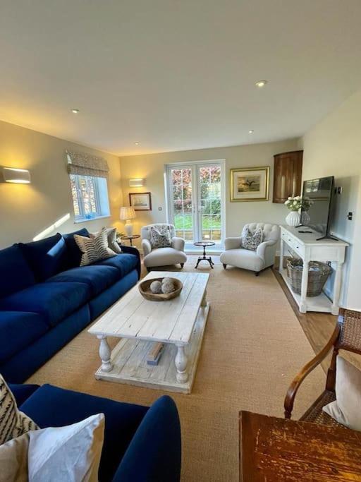 a living room with blue couches and a coffee table at Northbrook Cottage, Farnham, up to 8 adults in Farnham