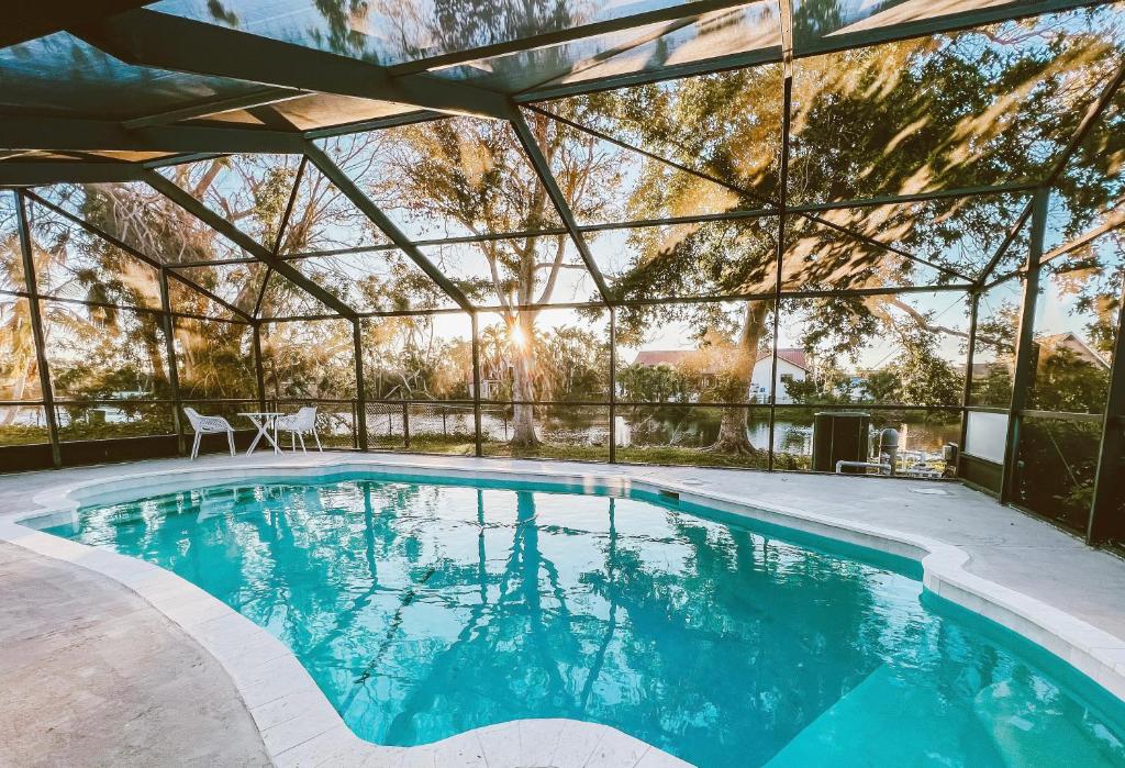 an indoor swimming pool with a large glass wall at Waterfront Home with Pool Minutes to Sanibel in Fort Myers