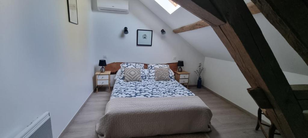 a bedroom with a bed in a attic at Meublé de tourisme &quot;Les brosses tillots&quot; in Mary