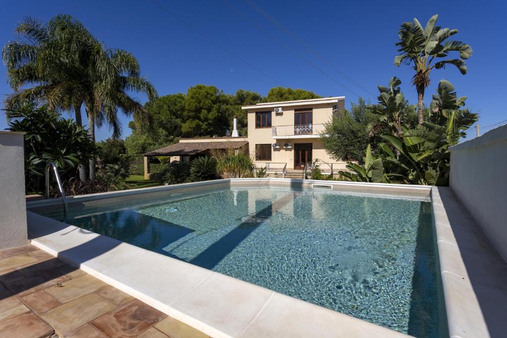 a swimming pool in front of a house at Villa Stella Nord in Marsala