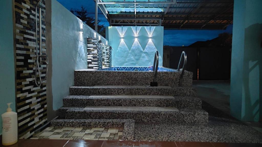 a set of stairs leading to a swimming pool at night at MunadibStay Private Pool in Ketereh