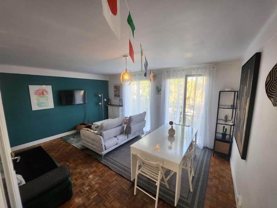 ein Wohnzimmer mit einem weißen Tisch und einem Sofa in der Unterkunft Maison proche Paris JO 2024 in Franconville