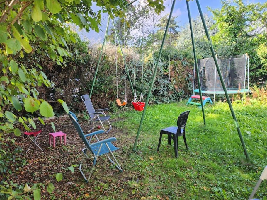 a group of chairs on a swing in a yard at Maison proche Paris JO 2024 in Franconville