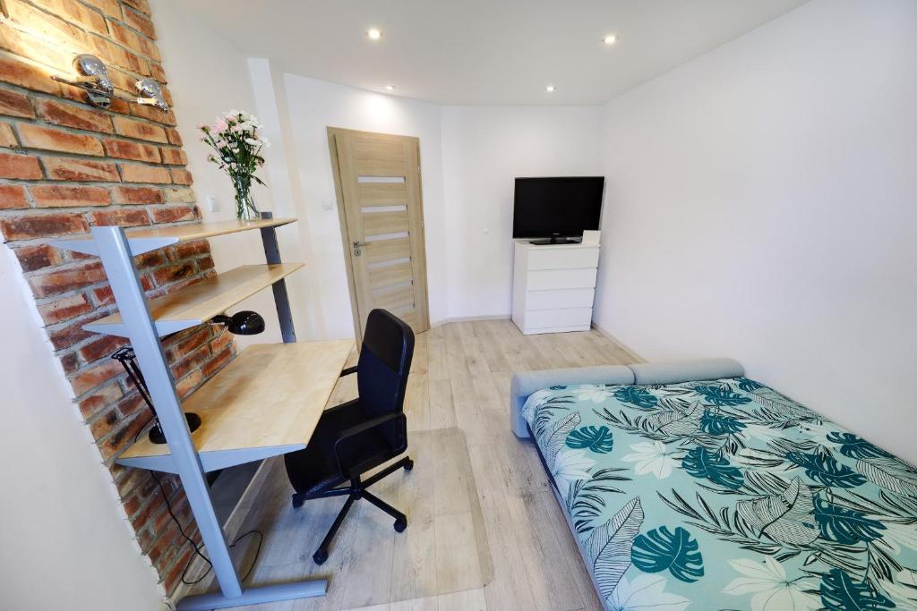 Mały pokój z łóżkiem i biurkiem oraz sypialnią w obiekcie Crystal Apartment II Katowice w mieście Katowice