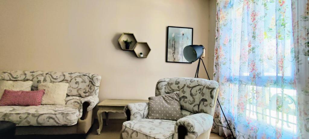 una sala de estar con 2 sillas y una lámpara. en CS50 Alojamiento 1 dormitorio Monforte de Lemos, en Monforte de Lemos