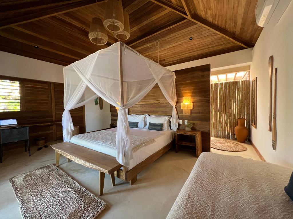 a bedroom with a bed with a canopy at LaVentana Tatajuba in Tatajuba