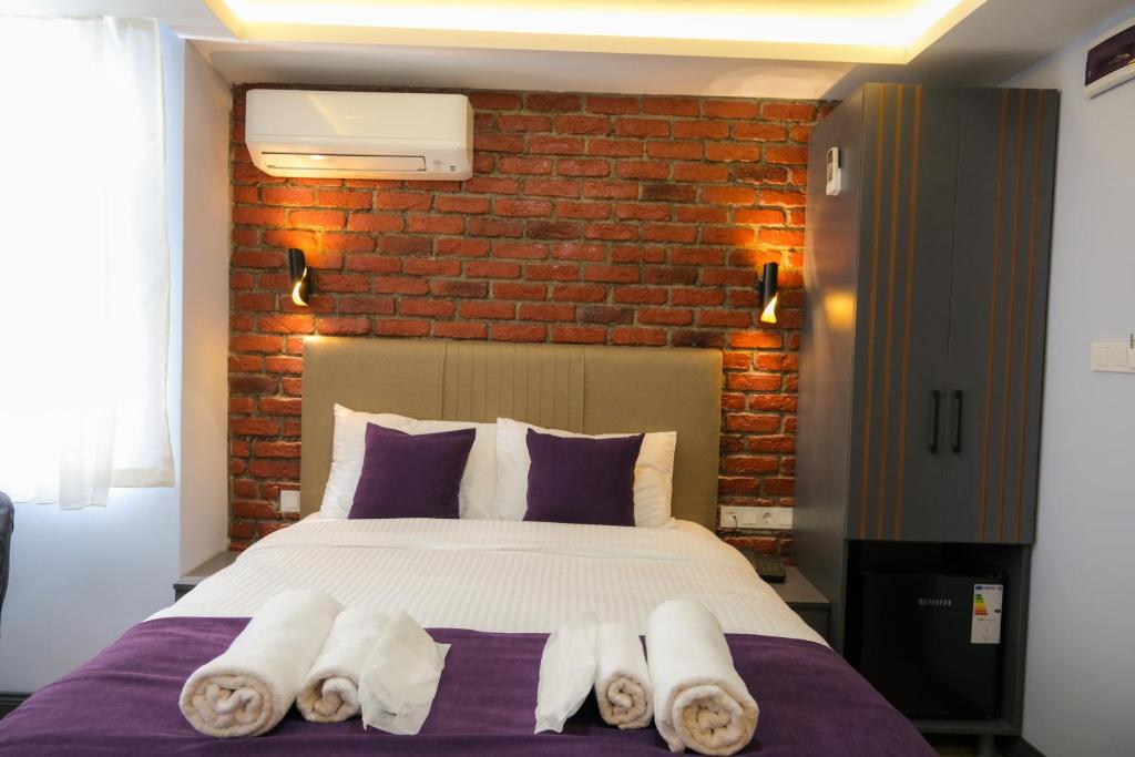 1 dormitorio con cama y pared de ladrillo en Yellow Mansion, en Estambul