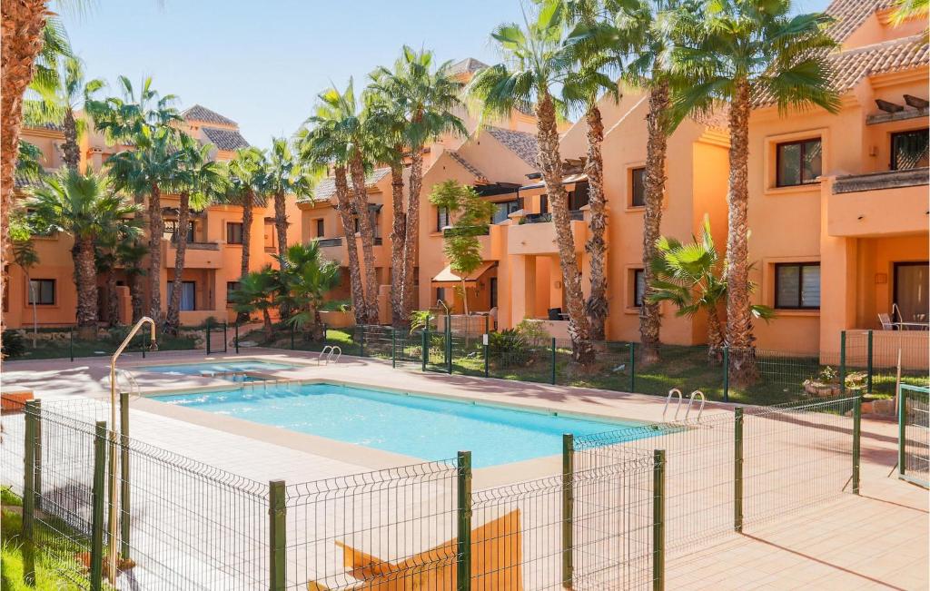 een zwembad voor een gebouw met palmbomen bij Nice Apartment In Los Alczares With Wifi in Los Alcázares