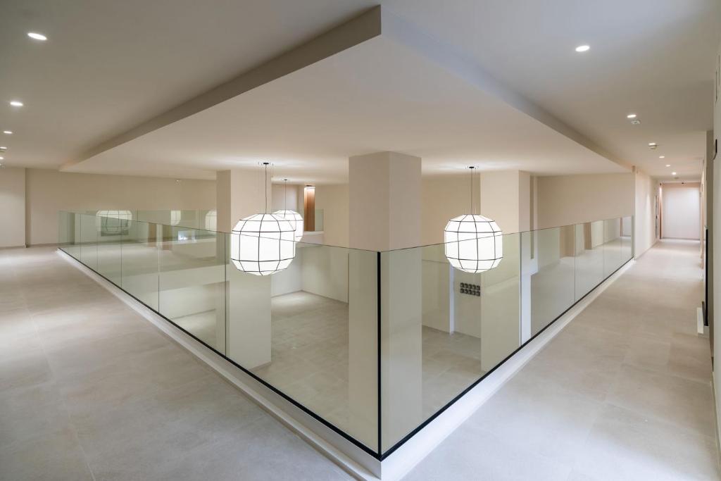 a hallway with a glass table and two pendant lights at Apartamentos Playa Victoria in Cádiz