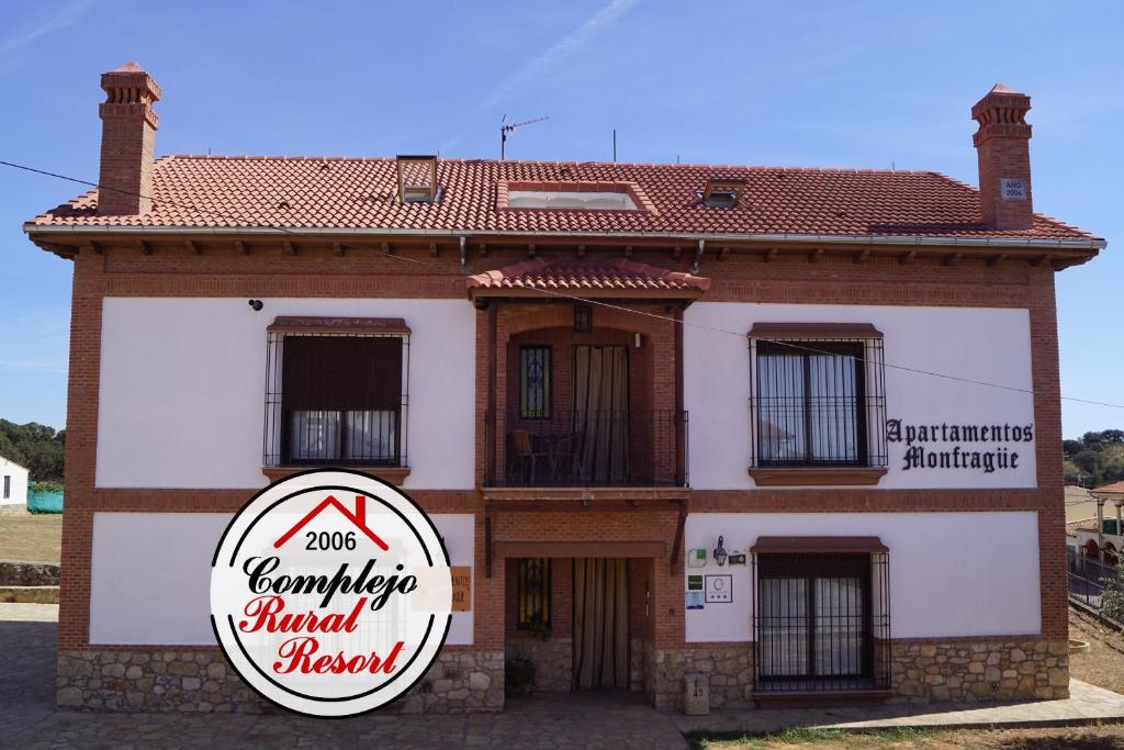 un edificio con una señal delante de él en Apartamentos Rurales Monfragüe en Torrejón el Rubio
