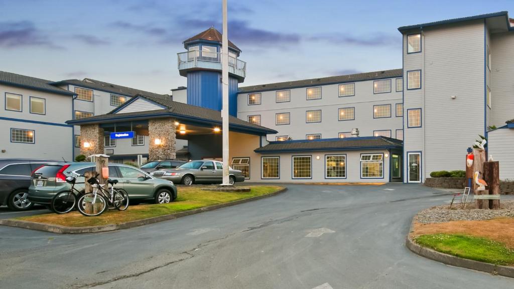 a parking lot in front of a hotel with a clock tower at Lighthouse Suites Inn in Ocean Shores