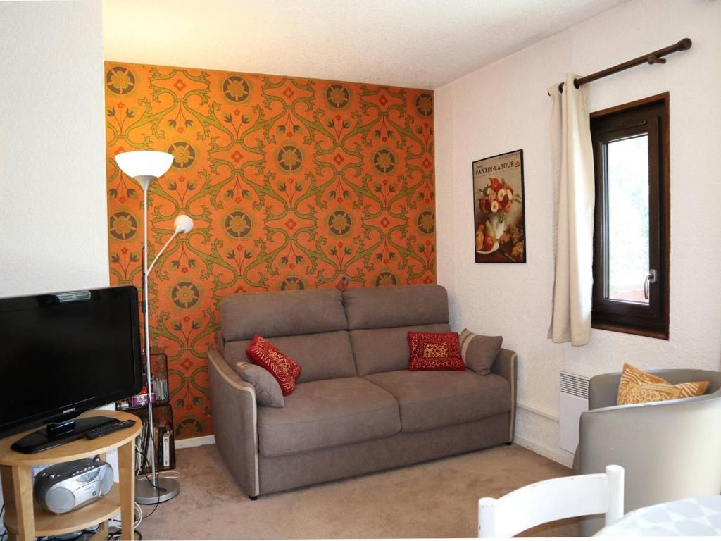 a living room with a couch and a tv at Appartement Les Orres, 1 pièce, 4 personnes - FR-1-322-219 in Les Orres