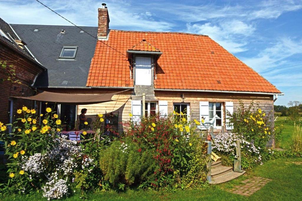 une maison avec un toit orange et un jardin dans l'établissement Chambres d'hôtes du Coq à l'Ane, à Beaubec-la-Rosière