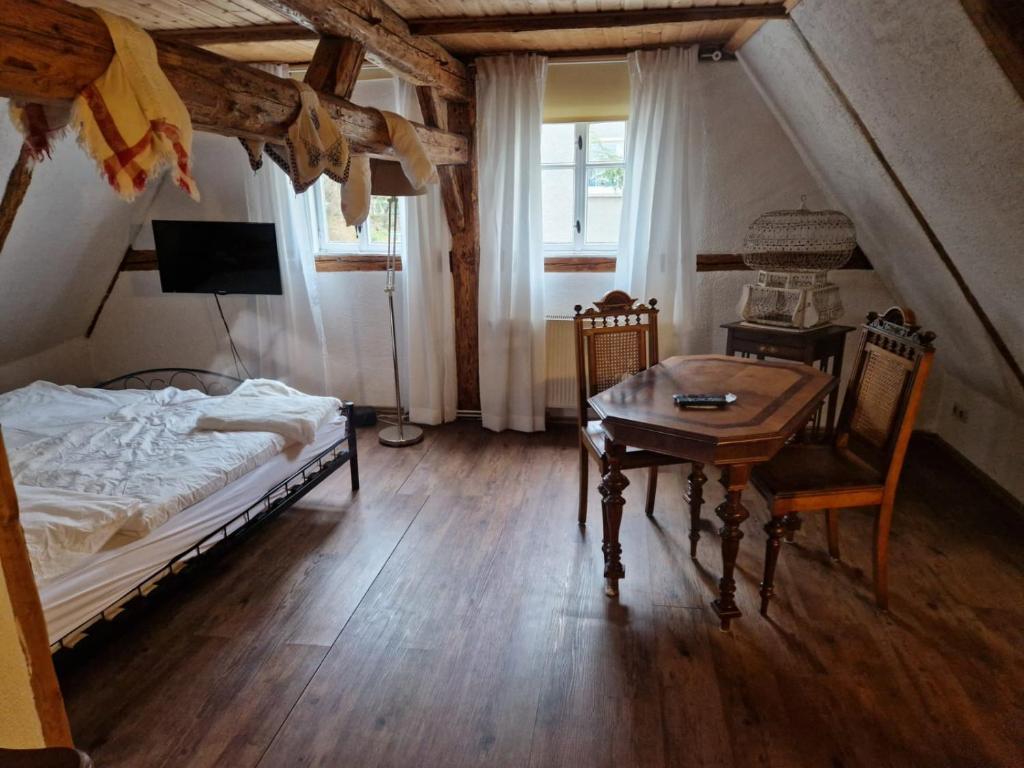 a bedroom with a bed and a table and chairs at Anno 1886 - Knepp-Hänel-Haus in Grünhainichen