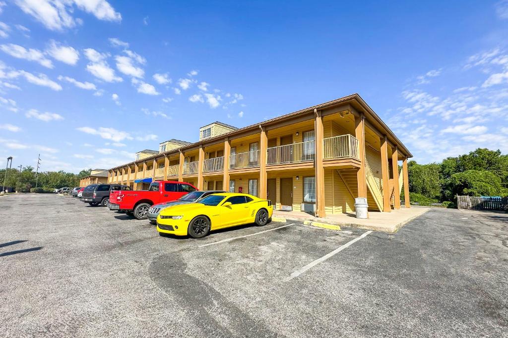 a yellow car parked in front of a building at Bonita Lakes Inn by Capital O Meridian I20 in Meridian