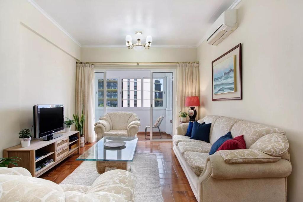 a living room with a couch and a tv at Central Living Funchal in Funchal
