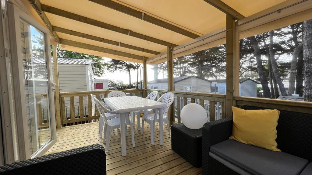 d'une terrasse avec une table et des chaises. dans l'établissement Mobil home 3 chambres 40 m2, à Quiberon